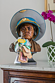 Carved wooden bust wearing military heat and labels on sideboard in Hampshire home UK