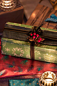 Schwarze Schleife und Beerenschmuck auf Weihnachtsgeschenk mit Teelichtern in Hampshire Cottage UK