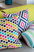 Colourful cushions on sofa in newbuild home Cornwall UK