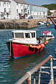 Red fishing boat in harbour Cornwall UK