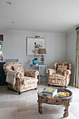 Pair of upholstered armchairs and low wooden coffee table in Oxfordshire home UK