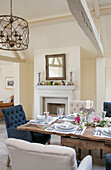 Buttoned chairs at wooden dining table in Oxfordshire home UK