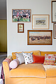 Equestrian artwork above yellow velvet sofa in London home UK