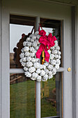 Christmas wreath on glass paned front door of Norfolk cottage England UK