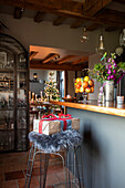 Als Geschenk verpacktes Weihnachtsgeschenk auf einem Barhocker in einer Küche in Norfolk England UK