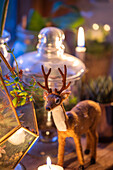 Reindeer ornament and lit candles in Norfolk cottage England UK