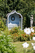 Light blue gazebo and statue in garden of Sussex home UK