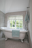Freistehende weiße Badewanne am Fenster in einem Haus in Sussex UK