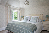 Karierte Decke mit passenden Vorhängen und Tapeten in einem Schlafzimmer in Sussex UK