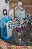 Bunte Cocktailgläser und Spirituosenflaschen auf einem Tablett in einem Londoner Haus UK