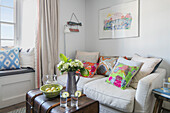 Colourful cushions and cut flowers in living room of Grade II listed cottage Cornwall UK
