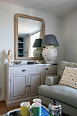 Large lamp on sideboard with mirror in Grade II listed cottage Cornwall UK