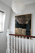 Moderne Kunst und Hängeschirm mit Geländer im Londoner Treppenhaus UK