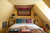 Wandbehang in einem Schlafzimmer im Dachgeschoss mit Hutständern in einem Haus in Sussex