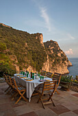 Tisch und Stühle auf der Terrasse einer italienischen Villa an der Amalfiküste