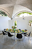 Black dining chairs at table in vaulted Italian Villa on the Amalfi coast Italy