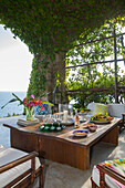 Niedriger Holztisch im Außenwohnzimmer einer italienischen Villa an der Amalfiküste