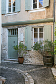 Fensterläden und Topfpflanzen vor einem französischen Stadthaus in Issigeac im Perigord Frankreich