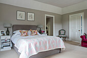 Floral cushions on double bed in Hampshire home England UK