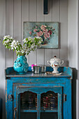 Cut flowers on vintage cabinet in Hampshire home England UK