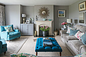 Armchair and buttoned ottoman with sofa in Hampshire living room England UK