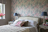 Grey lamps with floral wallpaper and cushion in Hampshire bedroom England UK
