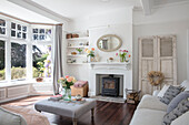 Cut flowers in sunlit pastel grey living room with original floorboard in Grade II listed country house Hertfordshire UK