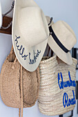 Embroidered sunhats and shopping bags hang in hallway of Grade II listed country house Hertfordshire UK
