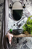 Badezimmer mit poliertem Marmor und Duschvorhang aus gewaschenem Leinen in einer umgebauten walisischen Scheune UK
