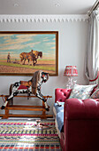 red leather sofa and rocking horse in 1840s Cotswolds cottage Oxfordshire UK