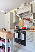 Shaker kitchen units in 'Stock Grey' with copper pans and butchers block in 1840s Cotswolds cottage Oxfordshire UK