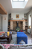 Wood burning stove and blue footstools with walls in 'Gooseberry Fool' 1840s Cotswolds cottage Oxfordshire UK