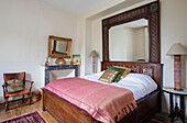 Indonesische Bettlampen und Spiegel mit antikem Stuhl und thailändischen Seidenstoffen im französischen Chateau Lot et Garonne