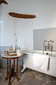 Klauenfußbadewanne mit antikem Marmorbeistelltisch in französischem Chateau Lot et Garonne