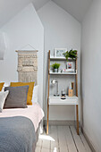 Leaning shelf unit at bedside in Victorian terraced house Manchester UK