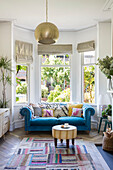 Blue Chesterfield sofa in bay window of Victorian terraced house Manchester UK