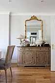 Vergoldeter Spiegel und hölzernes Sideboard in einem Landhaus in Surrey UK