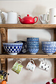 Bowls and cups on wooden shelves in Victorian cottage Midhurst West Sussex UK
