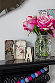 "Künstliche Rosen in einer Vase mit dem Buchstaben A"" und einer kleinen Ballerina in einer Dose in einem Haus in Derbyshire, UK"""