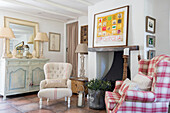 Upholstered antique chairs with painted sideboard and artwork in Surrey cottage UK