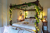 Four poster bed with ivy and fairylights in Georgian Hampshire cottage UK