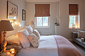 Co-ordinated pinks and soft whites in bedroom of London home UK