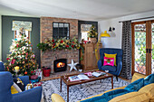 Modernes Wohnzimmer mit freiliegendem Ziegelsteinkamin und Weihnachtsbaum Surrey UK
