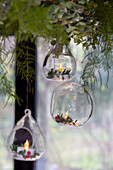 Three glass baubles hang in garland above dining table in Surrey home UK