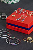 Pairs of earrings and red jewellery box London UK