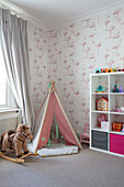 Teepee and rocking horse with shelf unit and Flamingos wallpaper in playroom of Victorian villa Tunbridge Wells Kent UK