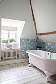 Bathroomdetails with windowseat above radiator and flamingo wallpaper in Hampshire UK