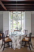 Glass topped dining table below chandelier Wales UK