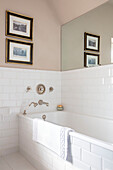 Spiegel über gefliester weißer Badewanne Wales UK