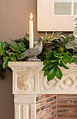 Stone dove candlestick with garland of leaves on mantlepiece Hampshire UK